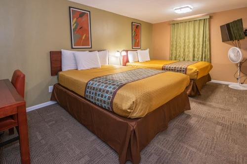 a hotel room with two beds and a table at Far West Motel in Forks