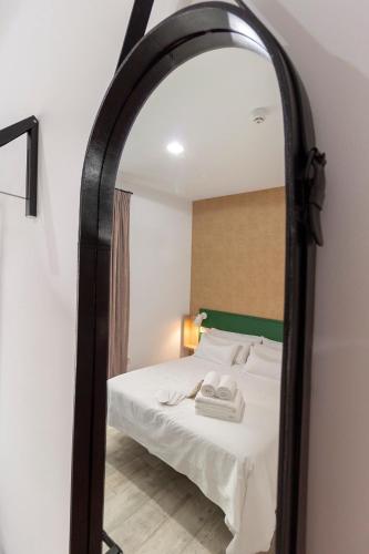 a bedroom with a bed and a large mirror at Hostal Casa de Luna y Sol in Úbeda