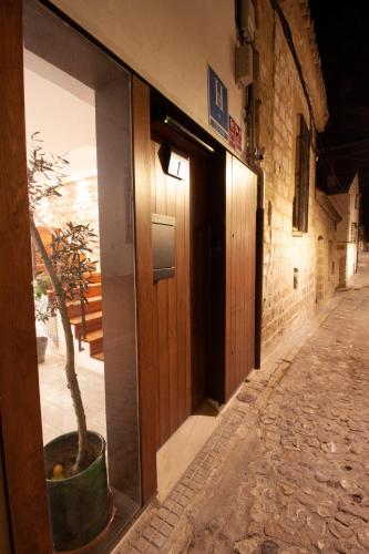 a door to a building with a tree in a pot at Hostal Casa de Luna y Sol in Úbeda