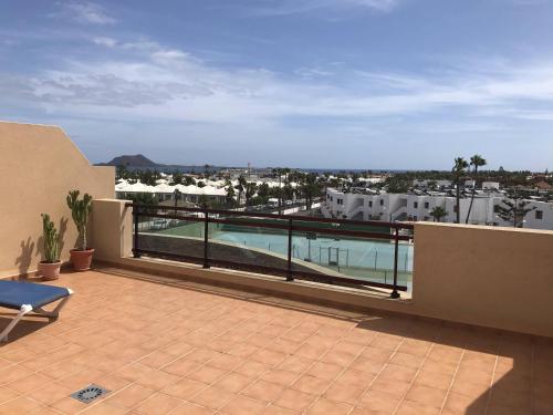 a balcony with a view of a swimming pool at Big and Bright Apartment in Corralejo
