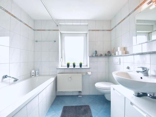 uma casa de banho com uma banheira, um lavatório e um WC. em Auszeit Apartment BODENSEE mit 4 Schlafzimmern, 600 m Luftlinie bis zum Bodenseeufer, in unmittelbarer Nähe des Bodenseeradwegs, schöne Sonnenterrasse, schnelles Internet, für bis zu 5 Personen em Friedrichshafen