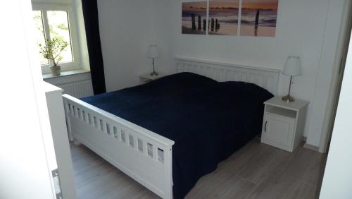 Un dormitorio con una cama con una manta azul. en Ferienwohnung Am Ochsenweg, en Hüsby
