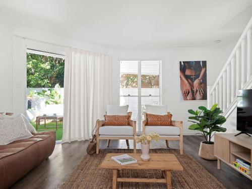 a living room with a couch and a table at The Bach in Byron in Byron Bay
