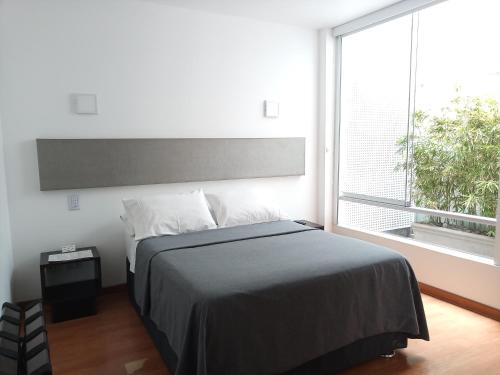 a bedroom with a bed and a large window at 3B Barranco's - Chic and Basic - B&B in Lima