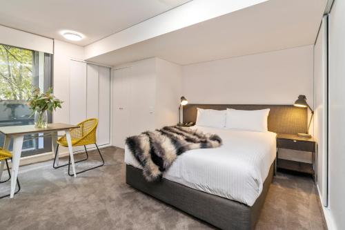 a bedroom with a bed and a desk and a table at Terminus Apartment Hotel Newcastle in Newcastle