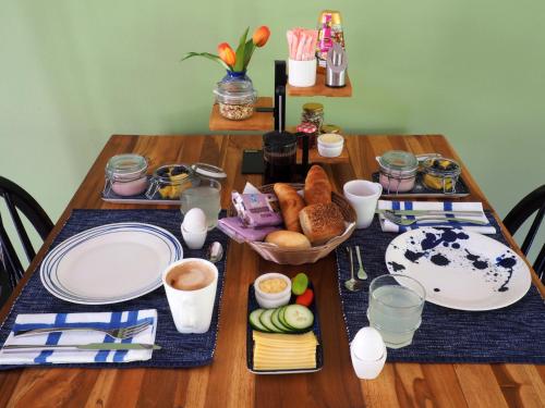 B&B Kas ChuChubi في كراليندايك: طاولة خشبية عليها لوحات وطعام