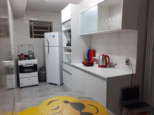 uma pequena cozinha com um frigorífico branco e uma mesa em Sobrado Livramento Rivera Diaria em Santana do Livramento