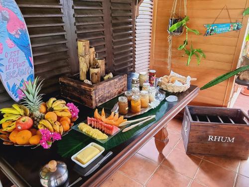 - une table avec un bouquet de fruits et de boissons dans l'établissement Gites Kaladja, à Port-Louis