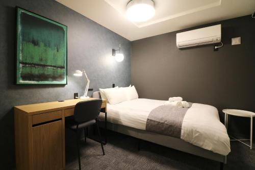 En eller flere senge i et værelse på TAKETO STAY PREMIERE SAPPORO Eki