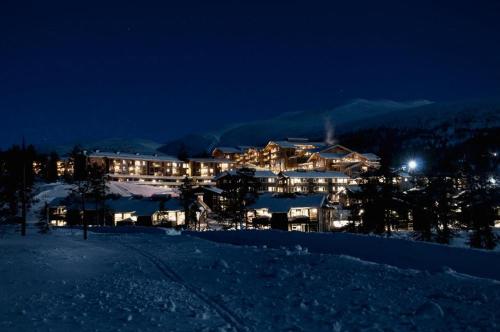 a large building on top of a snowy mountain at night at Norefjell Ski & Spa in Noresund