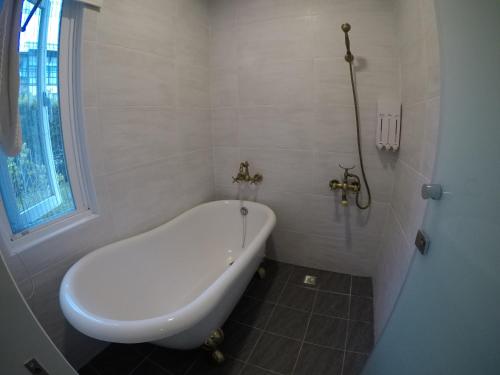 a white bath tub in a bathroom with a window at Flower Happiness Homestay in Jian
