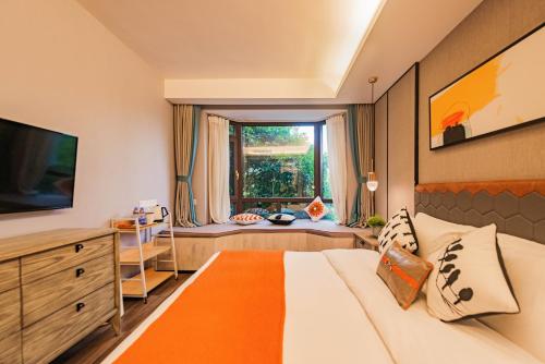 a bedroom with a large bed and a window at Li River Resort Villa Hotel in Guilin