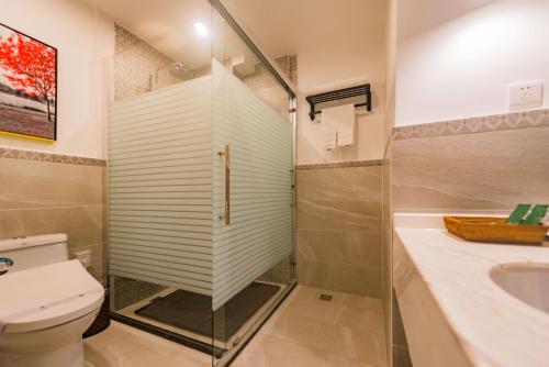 a bathroom with a shower and a toilet and a sink at Li River Resort Villa Hotel in Guilin
