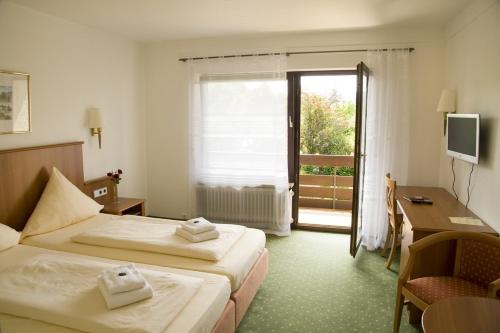 a hotel room with two beds and a desk and a window at aqualon Hotel Schweizerblick - Therme, Sauna & Wellness in Bad Säckingen