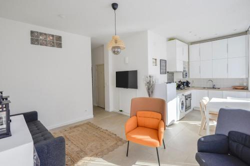 Il comprend un salon avec une chaise orange et une cuisine. dans l'établissement Chic And Modern Apt 5 Min From The Beach, à Marseille