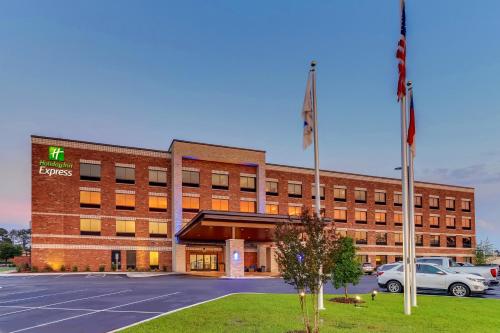 an office building with a car parked in a parking lot at Holiday Inn Express - Wilmington - Porters Neck by IHG in Wilmington