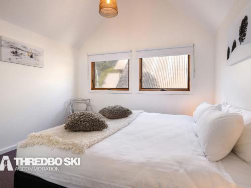 a bedroom with a white bed with two pillows on it at Granite Peaks 4 in Thredbo