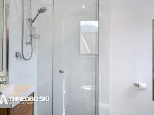 a shower with a glass door in a bathroom at Granite Peaks 4 in Thredbo