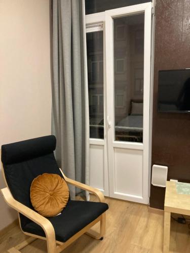 a living room with a chair and a window at Superbe Studio au 1er étage, proche de la gare du Midi in Brussels