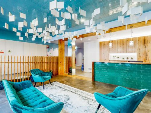 a lobby with blue chairs and a bar at Facing Bay Hostel in Praia da Vitória