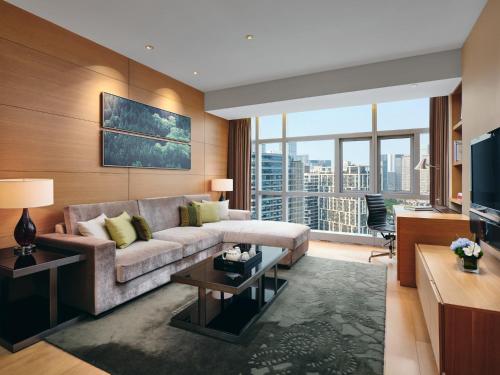 a living room with a couch and a large window at Grand ParcVue Hotel Residence Chengdu in Chengdu