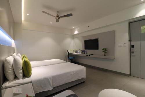 a bedroom with a bed and a tv on the wall at ZIBE Salem By GRT Hotels in Salem