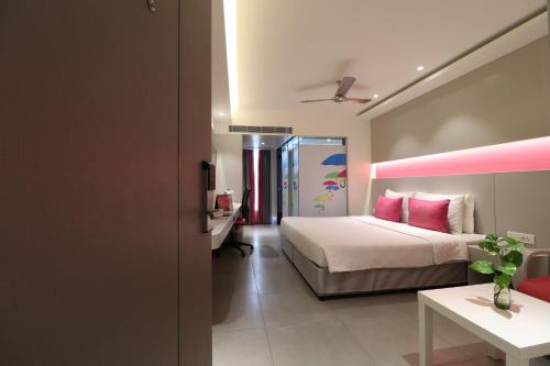 a bedroom with a bed and a pink room at ZIBE Salem By GRT Hotels in Salem