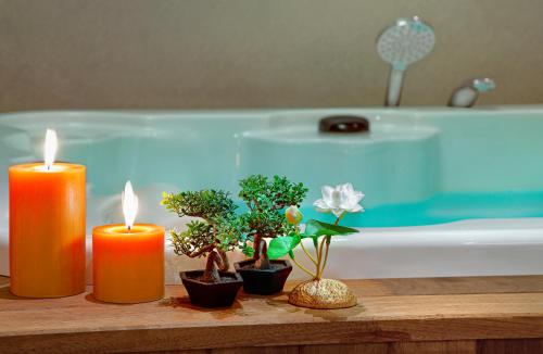 three candles sitting on a table next to a bath tub at Wanda Vista Istanbul in Istanbul