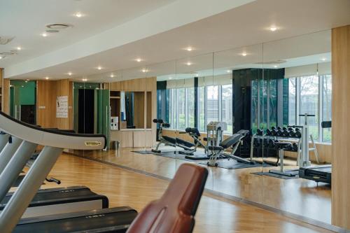 een fitnessruimte met loopbanden, crosstrainers en spiegels bij LOTTE City Hotel Gimpo Airport in Seoul