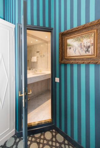 La salle de bains est pourvue d'une baignoire et d'une peinture murale. dans l'établissement Hôtel Saint Germain, à Paris