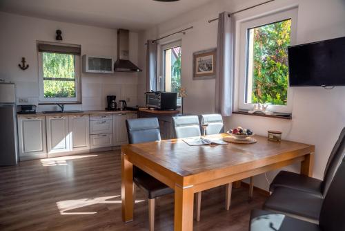 a kitchen and dining room with a wooden table and chairs at Dom Morski in Lubiatowo