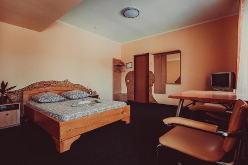 a bedroom with a bed and a desk and a chair at Formula 1 in Ivano-Frankivsʼk