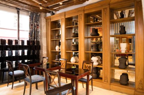 uma sala com mesas e cadeiras e prateleiras com vasos em Hôtel Saint Germain em Paris