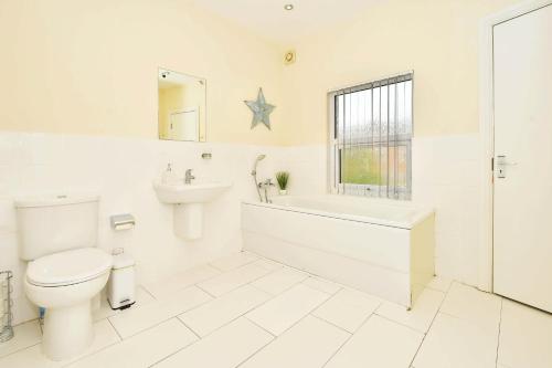 Baño blanco con aseo y lavamanos en Alexandra Terrace by YourStays, en Crewe