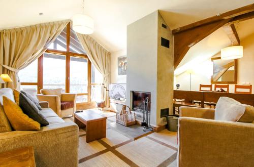 a living room with couches and a fireplace at Exceptional 3 bed Penthouse with fireplace and stunning views in Flaine