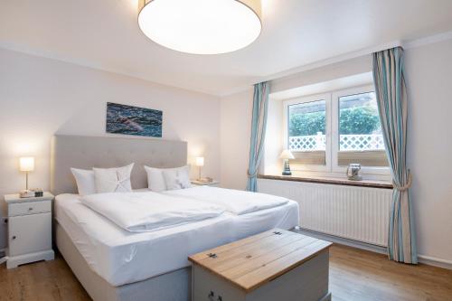 ein Schlafzimmer mit einem großen weißen Bett und einem Fenster in der Unterkunft Rosenstraße 1b Suite in Grömitz