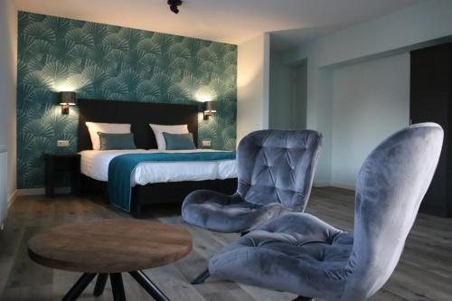 a bedroom with a bed and chairs and a table at Hotel Studio SIS in Steenbergen