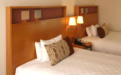a hotel room with two beds and two lamps at Akita Castle Hotel in Akita