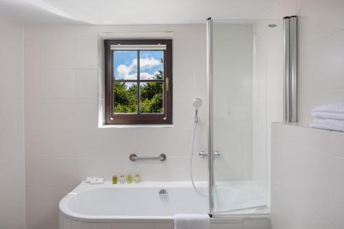 a bathroom with a shower and a toilet and a window at Fenomen Plitvice Gornja Jezera in Plitvica selo