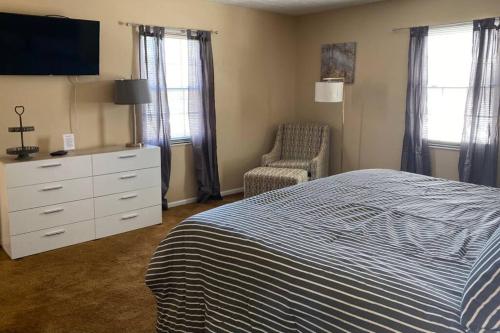 1 dormitorio con 1 cama, vestidor y silla en Ed's Englewood Well Furnished Home, en Englewood