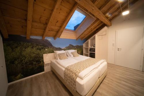 een slaapkamer met een groot bed en een schilderij aan de muur bij Hotel de la Concorde - Self Check-in in Vallorbe