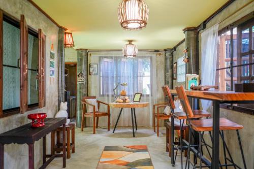 a living room with a table and chairs in a room at HEYUAN in Chiang Mai