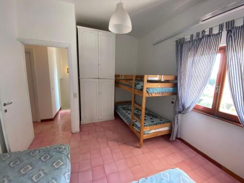 1 dormitorio con literas en una habitación con ventana en Villaggio Tognazzi Beach House, en Torvaianica