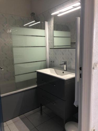 une salle de bain avec un lavabo et un miroir dans l'établissement BARCARESA-Villa de Louis piscine vue mer, Lydia et plage, au Barcarès