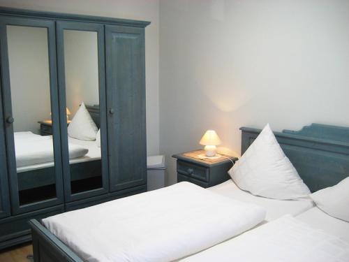 a bedroom with two beds and a large mirror at Ferienwohnungen Eleonore in Bad Birnbach