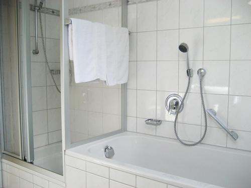 ein weißes Bad mit einer Dusche und einer Badewanne in der Unterkunft Ferienwohnungen Eleonore in Bad Birnbach