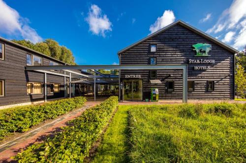 a green and white building in a rural area at Star Lodge Hotels in Utrecht