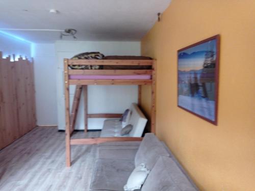 a small room with a bunk bed and a couch at Studio au Pied des Pistes avec Vue sur la Station 5 pl in La Mongie