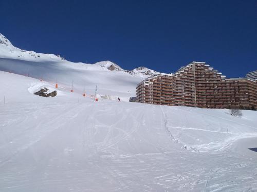 a snow covered slope with a building in the background at Studio au Pied des Pistes avec Vue sur la Station 5 pl in La Mongie