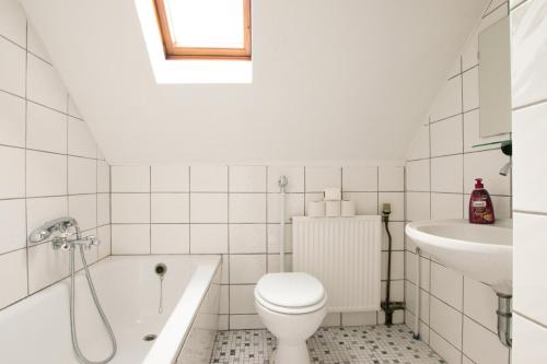 a white bathroom with a toilet and a sink at RAJ Living - 1 , 2 and 3 Room Monteur Apartments in Duisburg